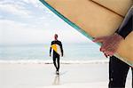 Man walking with surfboard on the beach