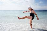 Happy senior woman splashing water with her feet