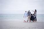 Family standing together and looking at sea