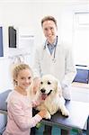 Girl standing with her dog while vet examining