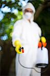 Man wearing protective workwear while spraying insecticide