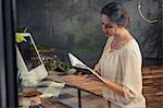 Businesswoman reading notebook on desk