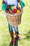 Woman holding a basket of freshly harvested vegetables