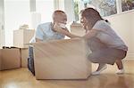 Young couple having fun while unpacking box