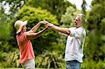 Senior couple enjoying while dancing in yard