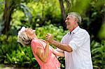 Senior woman laughing while dancing with man