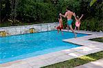 Father with daughter and son jumping into swimming pool