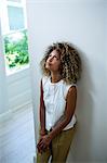 Tensed woman leaning on wall