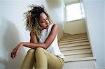 Tensed woman sitting on stairs