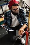 Bike mechanic looking at tablet computer