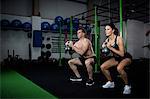 Man and woman exercising with kettlebell