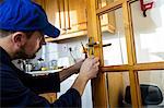 Man fixing the door handle with screwdriver