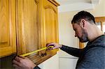 Handyman measuring a furniture with measuring tape