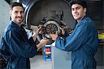 Mechanics examining car brake