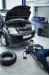 Mechanic using digital tablet while repairing a car