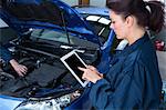 Female mechanic using digital tablet