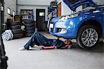 Female mechanic repairing a car