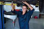 Female mechanic servicing a car