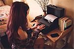 Young woman using typewriter