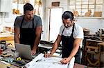 Two carpenters working in workshop