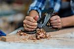 Female carpenter levelling a timber with jack plane