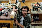 Portrait of male carpenter clamping wood