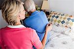 Nurse using stethoscope to take care of a senior man