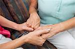 Nurse and senior woman holding hands