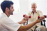 Nurse helping senior man with doing exercises