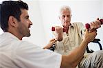 Nurse helping senior man with doing exercises