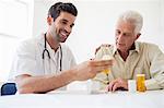 Nurse giving medicine to senior man