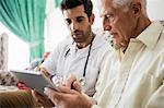 Nurse and senior man using tablet