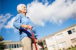 A senior woman walking with her walking stick