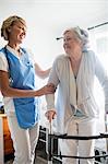Nurse helping senior woman to stand up
