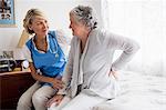 Nurse helping senior woman to stand up