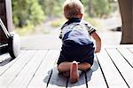 Baby boy crawling on porch