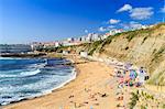 Top view of the village of Ericeira with the ocean waves crashing on the touristic sandy beach, Mafra, Portugal, Europe