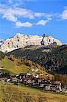 Colourful woods frame the village and the high peaks in autumn, Gardena Valley, South Tyrol, Trentino-Alto Adige, Italy, Europe