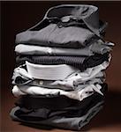 Stack of men's dress shirts on brown background