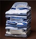 Stack of men's dress shirts on brown background