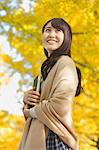 Young Japanese woman with book in a city park