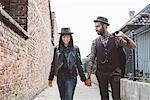 Young couple walking past brick wall