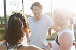 Two women and man training, chatting in sunlight