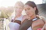 Portrait of two female friends training on urban footbridge