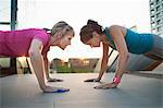 Two women training, doing push ups on stairway