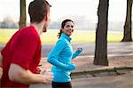 Young male and female runners running in park