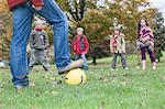 Father and children, playing football in park