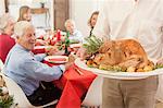 Man serving turkey to family at christmas dinner