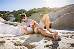 Couple lying on beach, head in lap smiling