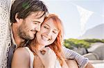 Head and shoulders of couple sitting hugging holding hands smiling